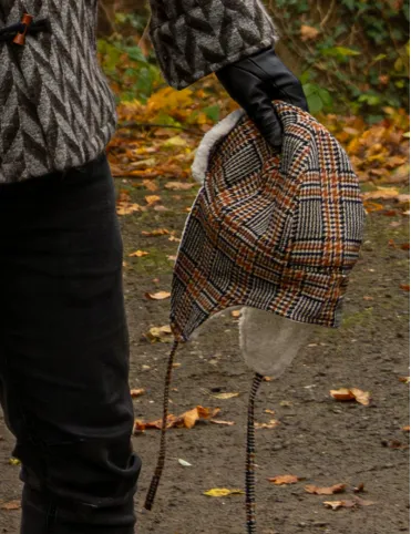 Warm woolen aviation-style earflap hat made of red tartan fabric