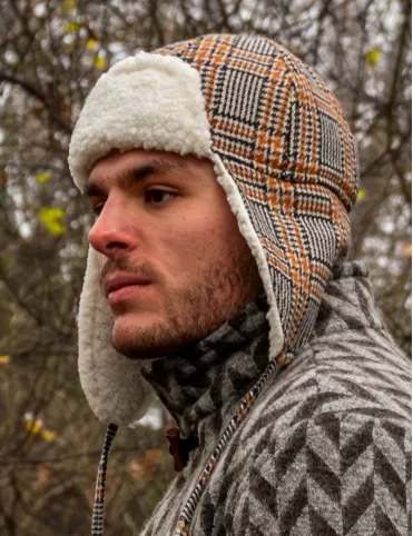 Warm woolen aviation-style earflap hat made of red tartan fabric